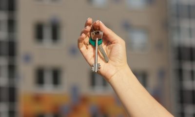 Chica sosteniendo las llaves de primer plano de apartamento nuevo, fondo borroso