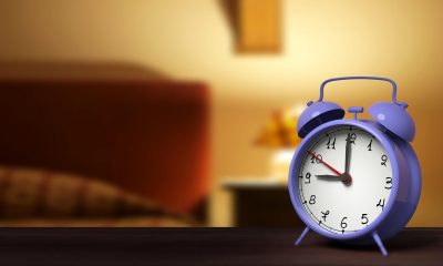 Primer plano de despertador retro con dormitorio en el fondo