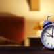 Primer plano de despertador retro con dormitorio en el fondo