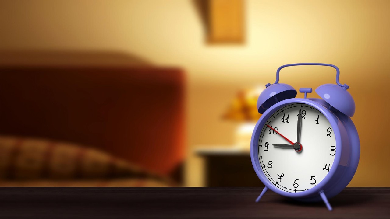 Primer plano de despertador retro con dormitorio en el fondo