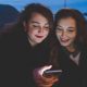 Jóvenes con móviles de noche en una calle urbana durante disturbios convocados por redes sociales